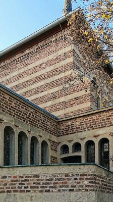 Kirchenbau mit Anbauten, Tuffbänder und Ziegelmauerwerk