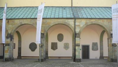 Seitenansicht der alten Wallfahrtskirche mit den Papstwappen