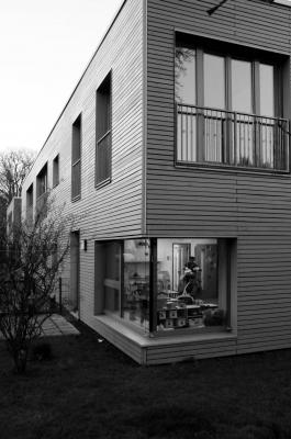 Holzverkleideter Baukörper mit verglaster Ecke
