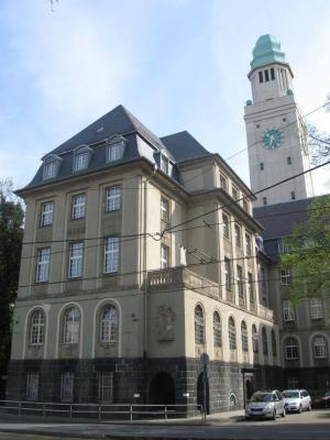 vorgezogener Seitenflügel mit Rathausturm im Hintergrund