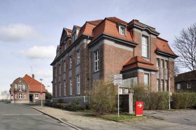 Blick auf die ehemalige Verwaltung mit Pförtnerhaus im Hintergrund