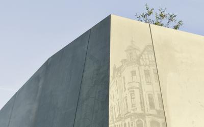 Sichtbetonwand mit Relief historischer Fotografien
