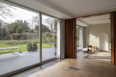 Innenansicht mit Blick durch die Fenster auf Terrasse und Garten