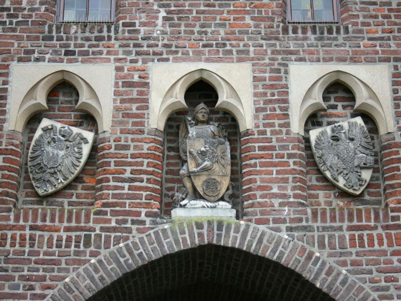 Steinmetzarbeiten über der Tordurchfahrt mit Wappen und Stadtpatron St. Georg