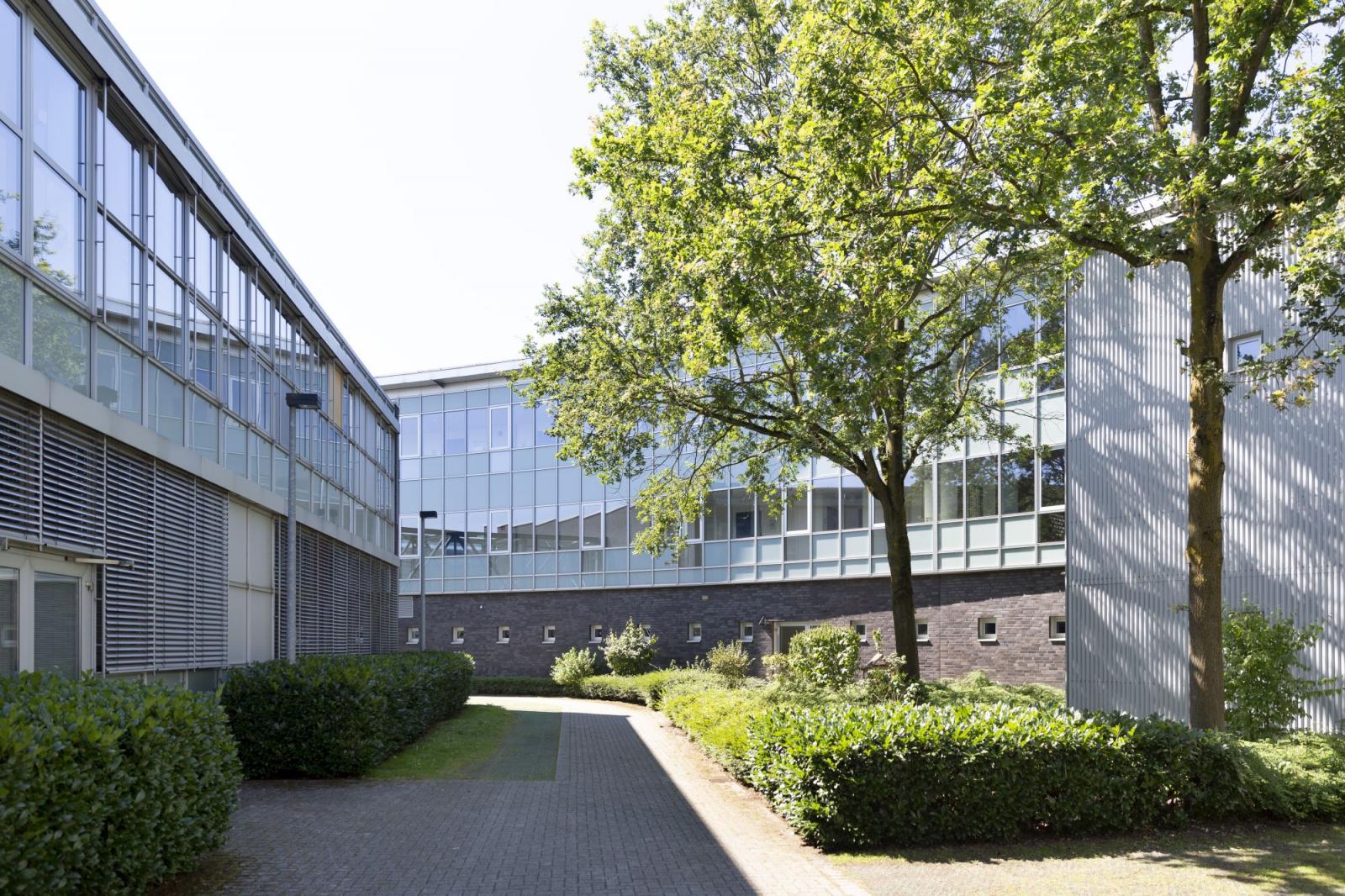 bogenförmiges Hauptgebäude mit Riegelbau