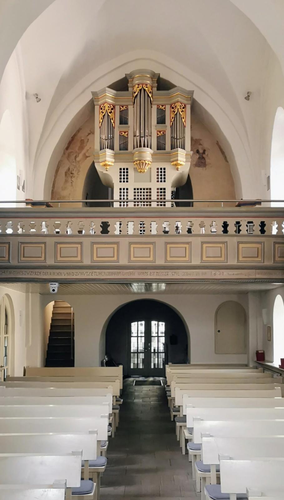 Kircheninnenraum mit Orgelempore und Eingang