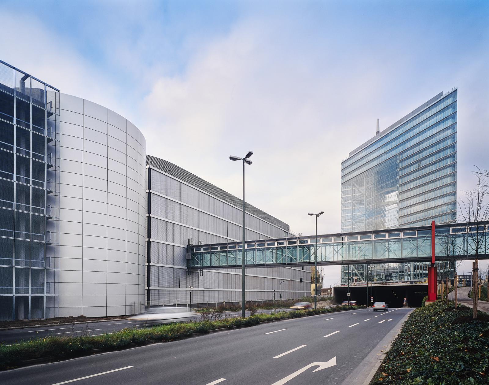Bürogenäude mit gläserner Verbindungsbrücke, dahinter das Stadttor Düsseldorf