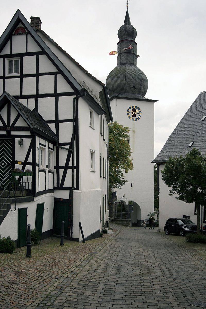 Fachwerkhaus mit dem Turm der Stadtkapelle St. Georg im Hintergrund