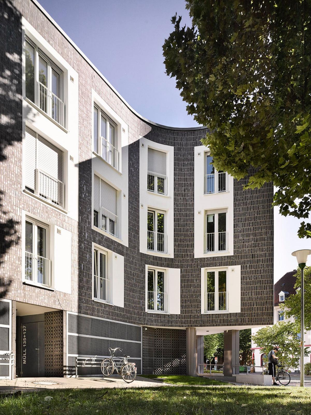 Fassade mit dunklen Klinkern und weißen Fensterumrandungen