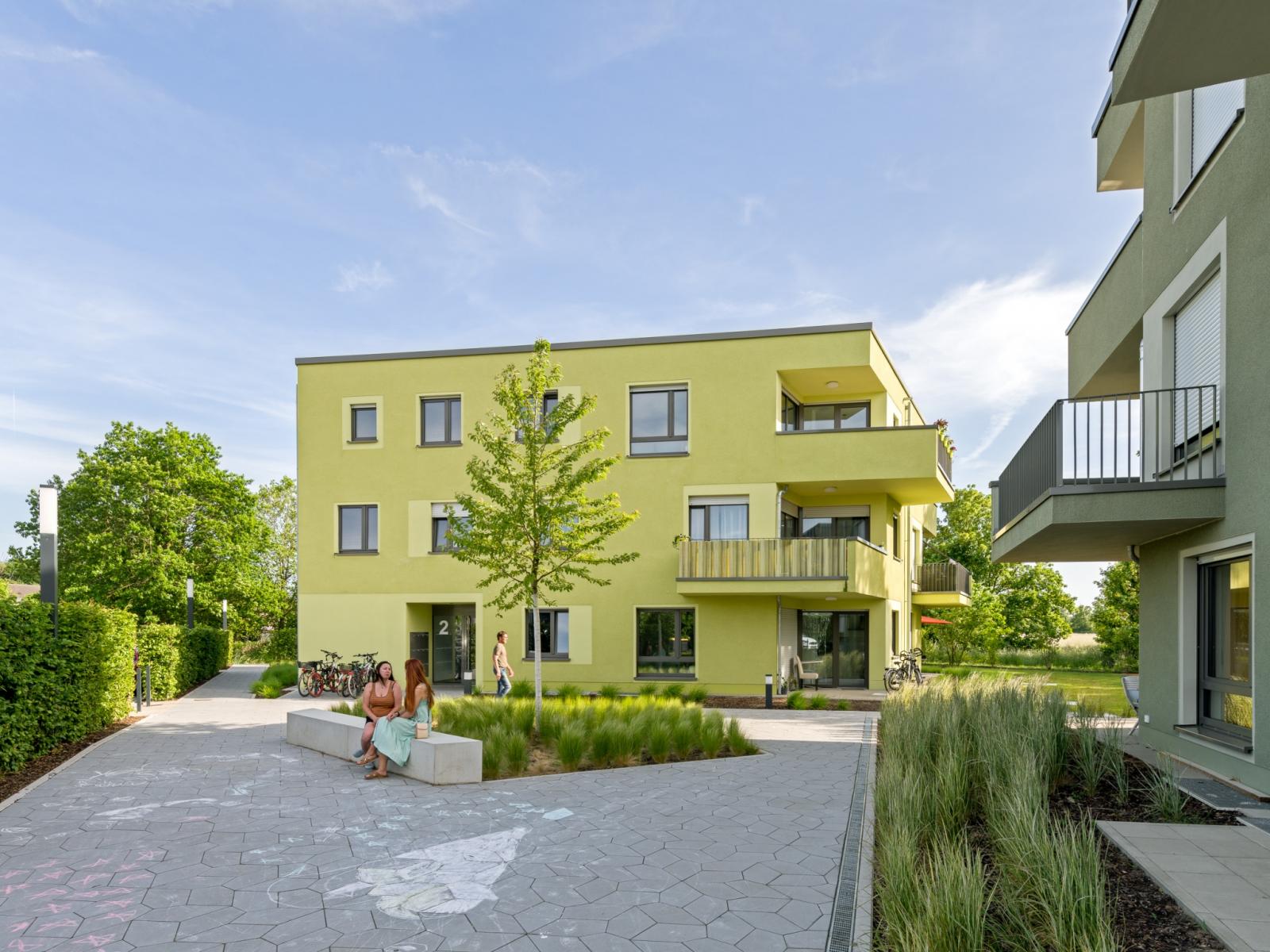 Typenhäuser für Geflüchtete, Vorplatz, polygonale Baukörper