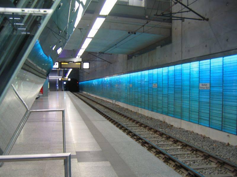 Bahnsteigkante und hinterleuchtete Glaswand
